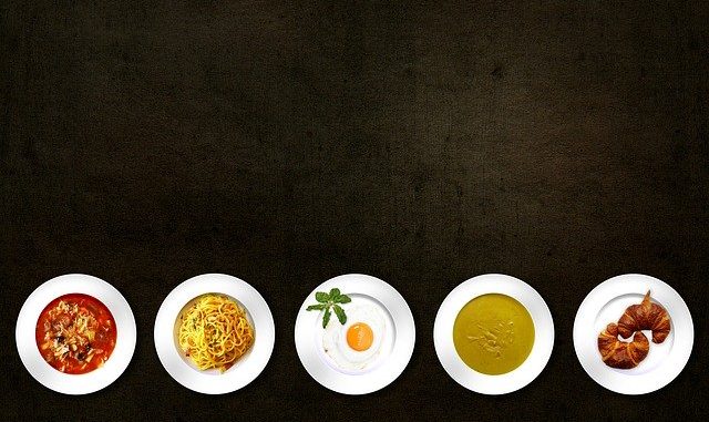 Ciemny stół na którym stoją talerze z jedzeniem