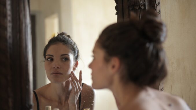 Kobieta ogląda swoją twarz w lustrze